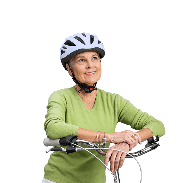 Ältere Frau mit Fahrradhelm aufgestützt auf Fahrradlenker