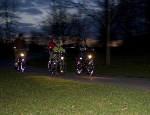 Vier Fahrradfahrer im Dunkeln mit Beleuchtung