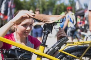 Frau stellt Sitzposition des Fahrradsattels ein
